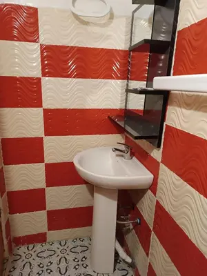 a bathroom with a sink and red and white checkered wall at Riad Amira Fes in Fès