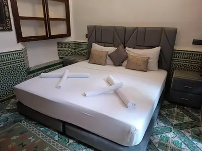 a large white bed with two crosses on it at Riad Amira Fes in Fès