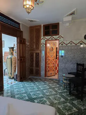 a living room with a tile floor and a door at Riad Amira Fes in Fès
