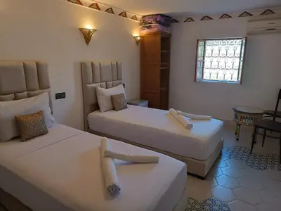 a hotel room with two beds and a table at Riad Amira Fes in Fès