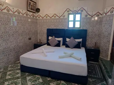 a bedroom with a large bed with two crosses on it at Riad Amira Fes in Fès