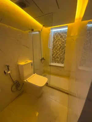 a bathroom with a toilet and a glass shower at Appartement Dar LALA 2 in Fès
