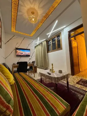 a room with a bed and a table and a television at Appartement Dar LALA 2 in Fès