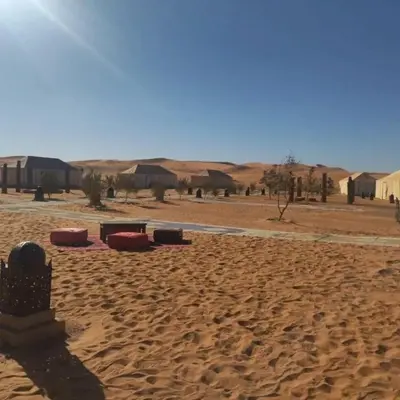a desert with houses and buildings in the distance at Golden Sahara camp in Merzouga