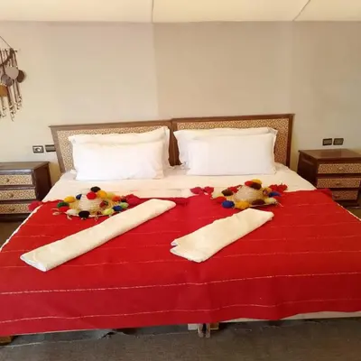 a bed with two towels and stuffed animals on it at Golden Sahara camp in Merzouga