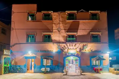a building with a gate in front of it at night at hotel dar aicha in Tinerhir