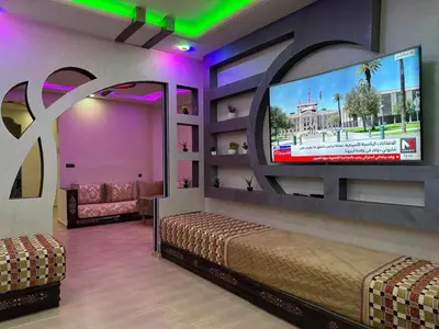 a room with a flat screen tv and a bed at apartment for guests in Demnat