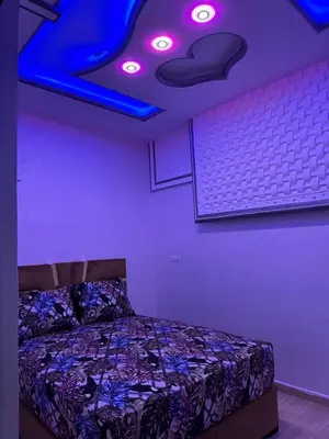 a bedroom with a bed with purple lights on the ceiling at apartment for guests in Demnat