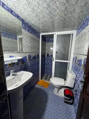 a blue and white bathroom with a toilet and sink at apartment for guests in Demnat