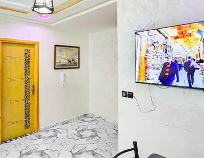 a room with a television on a wall at Appart Hotel Bab Fes Medina - For Families & Travelers in Fès