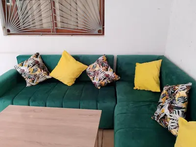 a green couch with yellow pillows on it at apartment near Super Market in Meknès