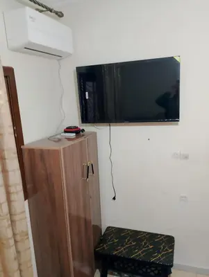 a tv on a wall above a wooden cabinet at apartment near Super Market in Meknès