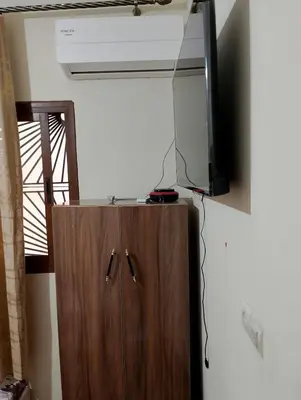 a room with a television and a wooden cabinet at apartment near Super Market in Meknès