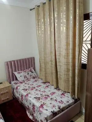 a bedroom with a bed with a pink bedspread at apartment near Super Market in Meknès