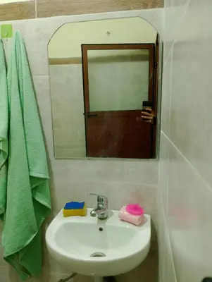 a bathroom with a sink and a mirror and green towels at apartment near Super Market in Meknès