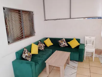 a living room with a green couch with yellow pillows at apartment near Super Market in Meknès