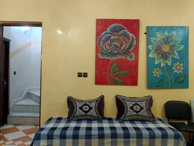 a bedroom with two pillows and paintings on the wall at شقة مفروشة بمكناس قرب مركز التسوق مرجان in Meknès
