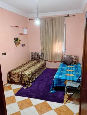 a room with a bed and a table and a window at شقة مفروشة بمكناس قرب مركز التسوق مرجان in Meknès