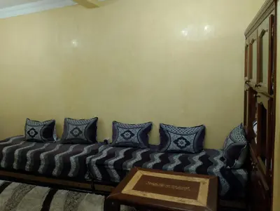 a couch in a room with blue pillows at شقة مفروشة بمكناس قرب مركز التسوق مرجان in Meknès