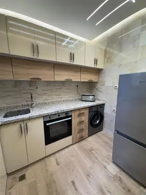 a kitchen with white cabinets and a refrigerator at Appartement Dar LALA 1 in Fès