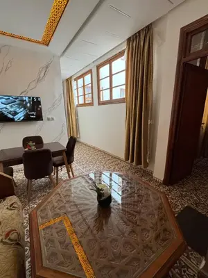 a living room with a table and a tv at Appartement Dar LALA 1 in Fès
