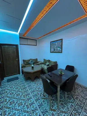 a living room with a table and a couch at Appartement Dar LALA 1 in Fès