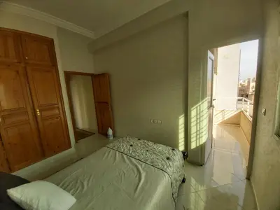 a bedroom with a bed and a large window at Location Appartement pour Familles in Fès