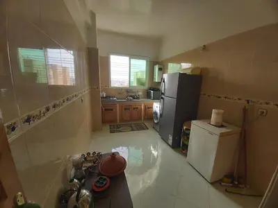 a kitchen with a refrigerator and a counter top at Location Appartement pour Familles in Fès