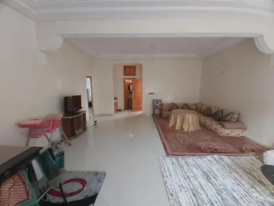a living room with a couch and a table at Location Appartement pour Familles in Fès