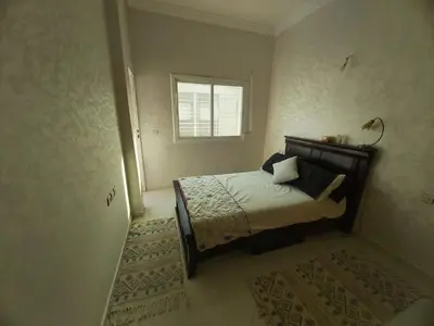 a bedroom with a bed and a window at Location Appartement pour Familles in Fès