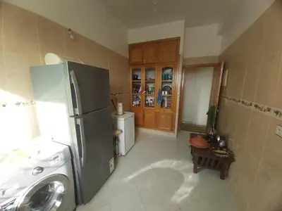 a kitchen with a refrigerator and a washing machine at Location Appartement pour Familles in Fès