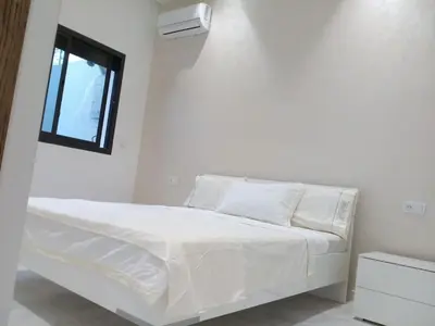 a white bed in a white room with a window at Calme Climatisé Bien Situé Fibre 92Mbs à Bourmana in Fès