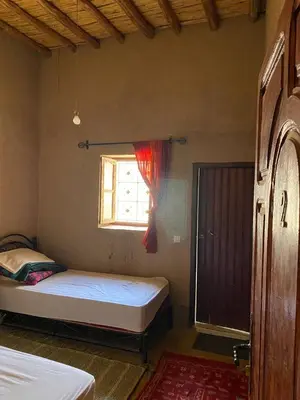 a bedroom with two beds and a window at Dar tata in Hassilabied