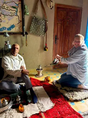 two people sitting on the floor in a room at Dar tata in Hassilabied