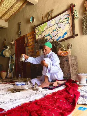 a man sitting on the floor in a room at Dar tata in Hassilabied