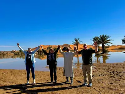 a group of people standing in front of a body of water at Dar tata in Hassilabied