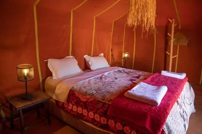 a bedroom with a bed with two towels on it at Touaregs Camp Erg Lihoudi in Mhamid