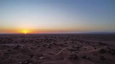 an aerial view of the desert at sunset at Touaregs Camp Erg Lihoudi in Mhamid
