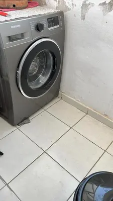 a washing machine sitting on a tiled floor next to a wall at واد فاس in Fès