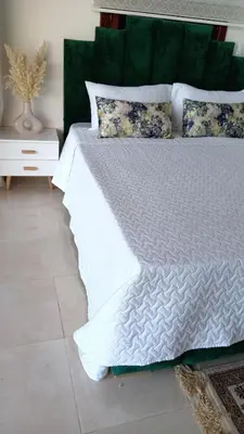 a bed with white sheets and pillows in a room at Coin des bons moments in Marrakech