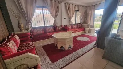 a living room with red couches and a table at Coin des bons moments in Marrakech