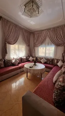 a living room with red couches and a table at Maison Taha in Azrou
