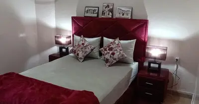 a bedroom with a large bed with two lamps at Maison Taha in Azrou