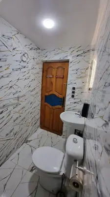 a bathroom with a toilet and a wooden door at Maison Taha in Azrou