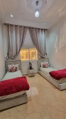 a bedroom with two beds and a window at Maison Taha in Azrou