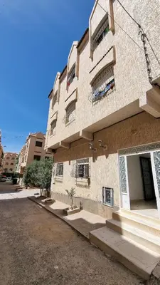 a tall building with stairs next to a street at Maison Taha in Azrou