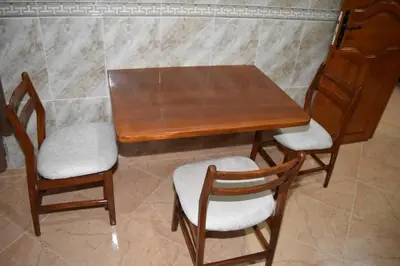 a wooden table with two chairs and a table at Maison Taha in Azrou