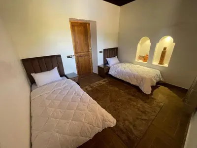 a bedroom with two beds and two mirrors at Sandy farm in Ouled el guerne