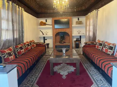 a living room with two couches and a fireplace at Sandy farm in Ouled el guerne