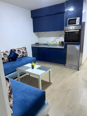 a living room with a blue couch and a table at Escapade à Fes in Fès